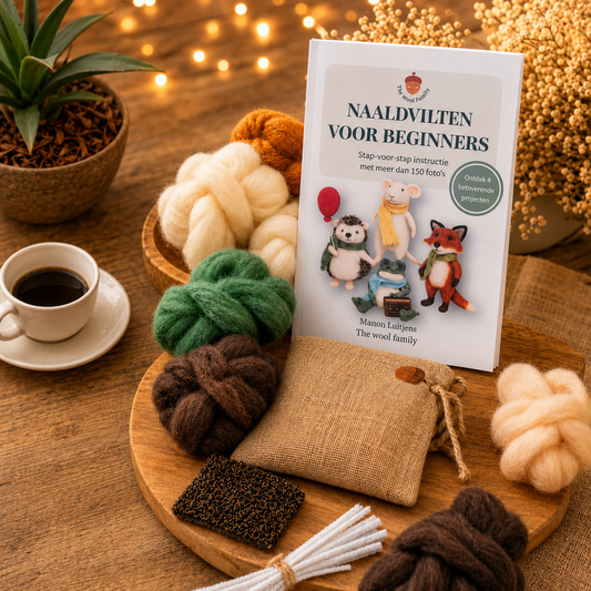 Book titled 'Naaldvlitlen voor Beginners' on a wooden table with wool and coffee.