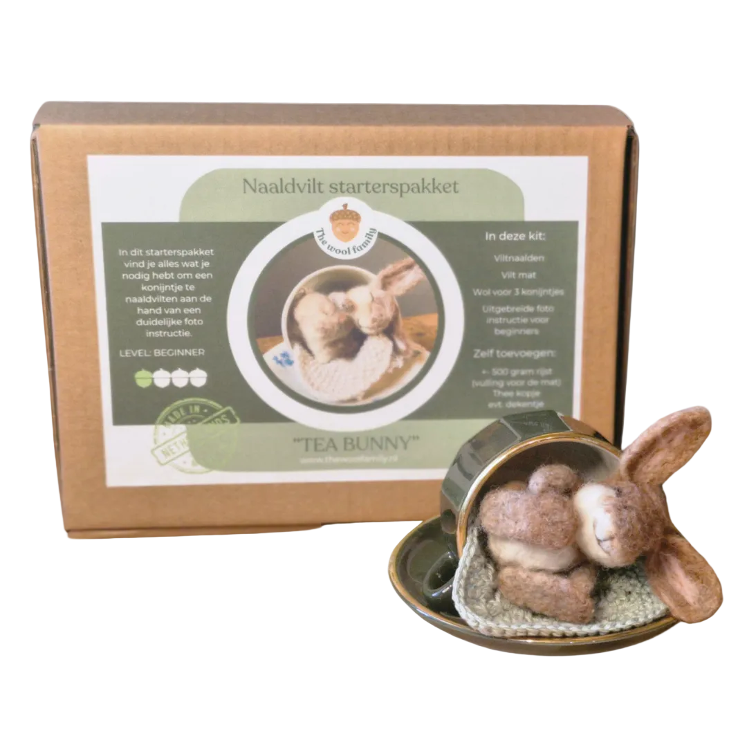 A needle felt kit package with the image of a bunny on it, alongside a prepared bunny-shaped felt craft displayed in a cup.